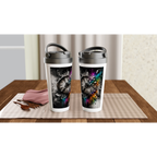 Two 15oz stainless steel travel mugs displayed on a wooden table, each featuring a surreal street art design of a shattered vintage clock. The artwork blends a predominantly black-and-white composition with vibrant rainbow powder splashes, geometric fragments, and expressive paint drips, creating a bold artistic interpretation of time and transformation.