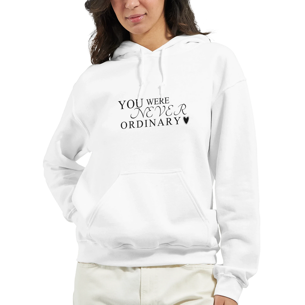 Close-up of a female model wearing a white hoodie with the black “You Were Never Ordinary” statement design on the front, shown from the chest up.
