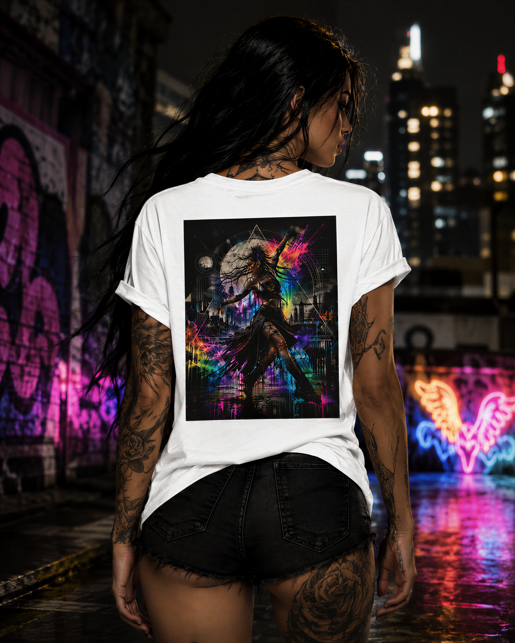 Tattooed woman wearing a Personiq Kaleido T-Shirt with colorful neon street art artwork on the back in an urban night setting.