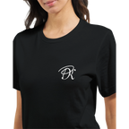 Close-up of a female model wearing a black “Color the Grey” unisex T-shirt, featuring a subtle white PK monogram on the front chest.