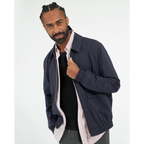 Male model wearing a black “Color the Grey” unisex T-shirt layered under a dark casual jacket, styled in a clean contemporary look.