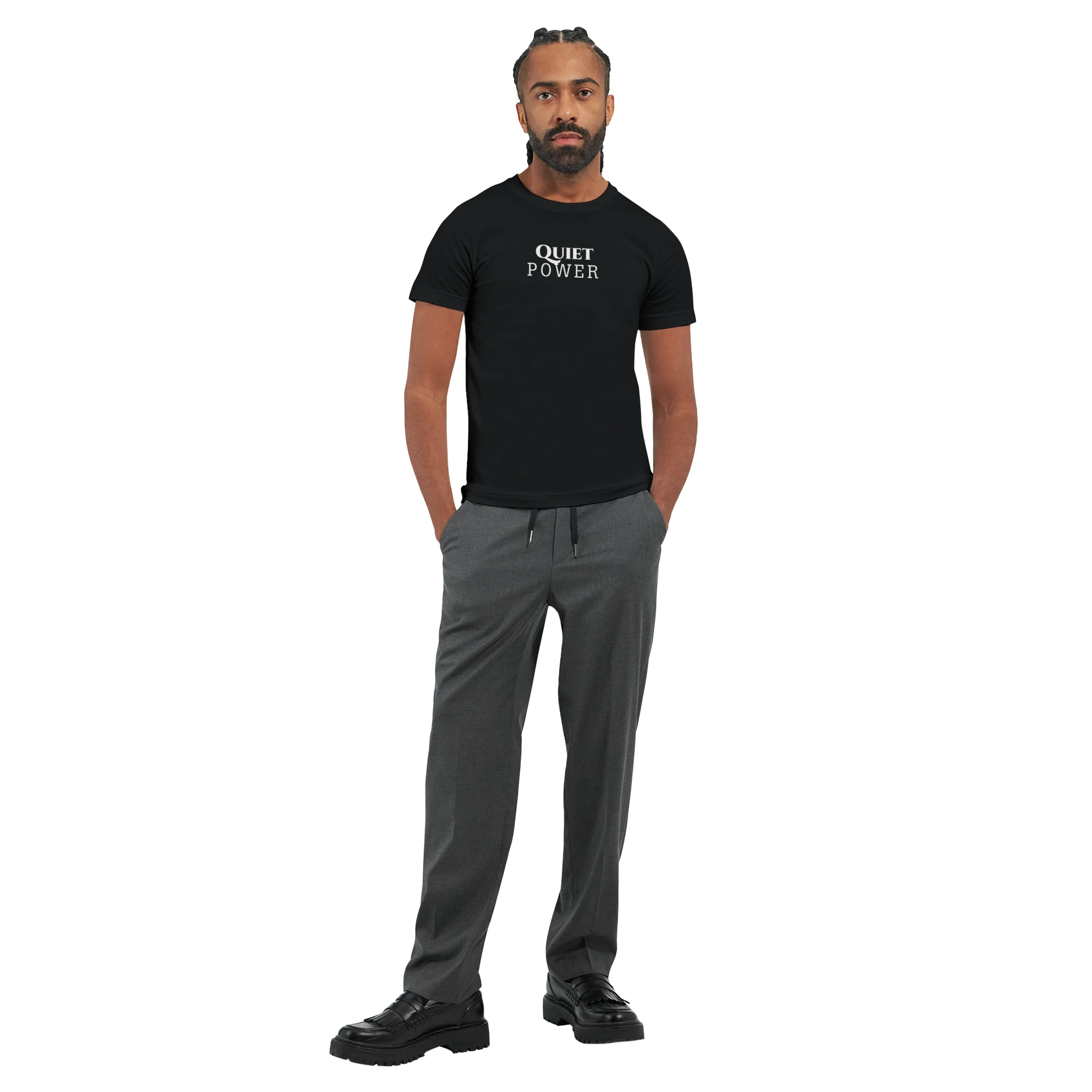 Full-body male model wearing a black unisex T-shirt with the small white “QUIET POWER” chest print, paired with gray trousers.