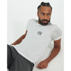 Male model wearing a white T-shirt with a small black PK logo on the chest, styled with dark trousers in a clean, minimal studio setting.