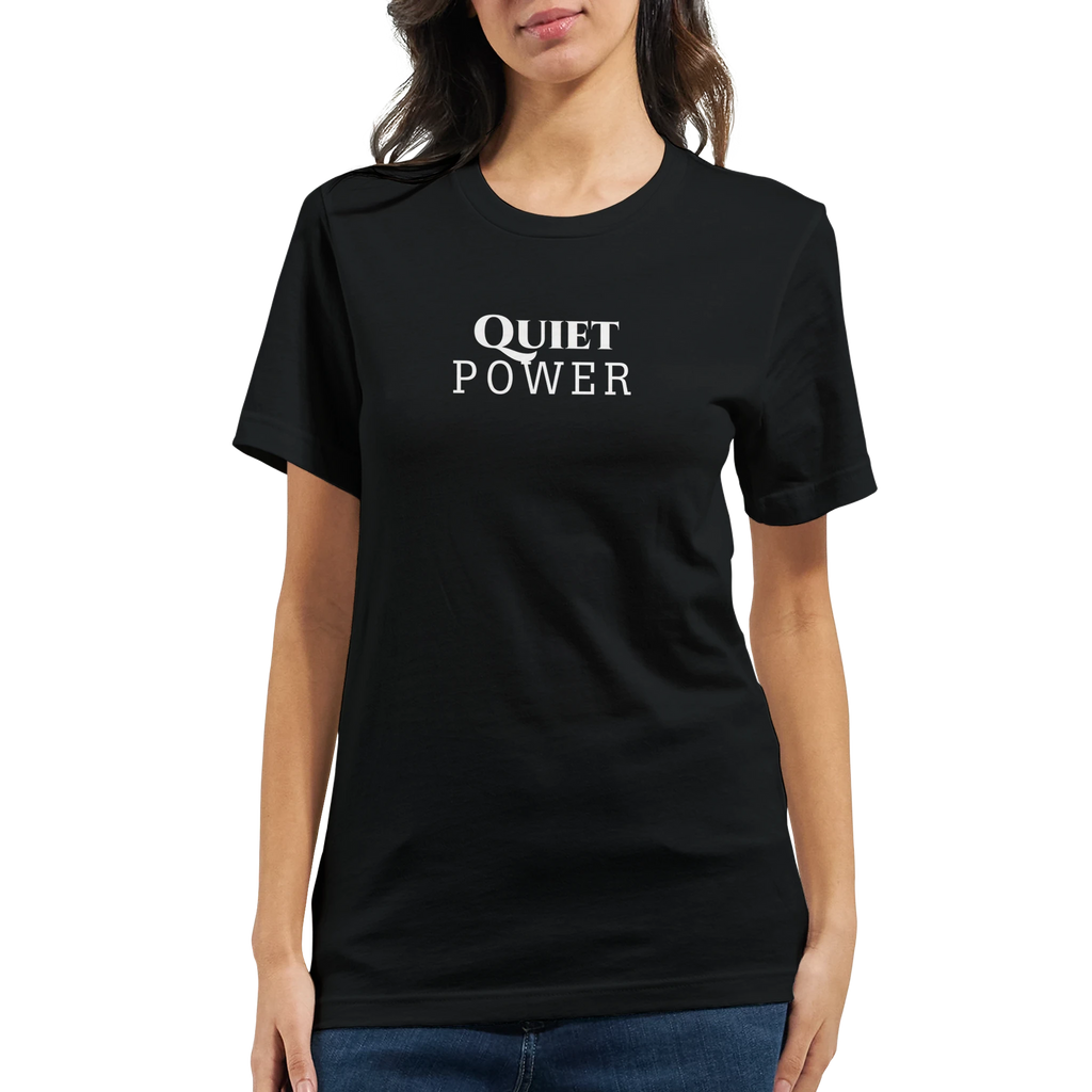 Female model wearing a black unisex T-shirt with a small white “QUIET POWER” chest print, shown from the front with blue jeans.