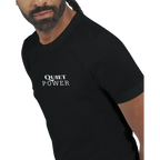 Close-up of a male model wearing a black unisex T-shirt with a small white “QUIET POWER” print centered on the chest.