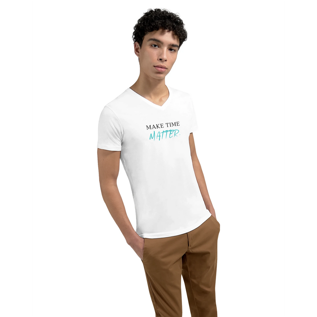 Young model wearing a white premium unisex V-neck T-shirt featuring the minimalist statement 'MAKE TIME MATTER.' on the front. The clean typography combines black serif lettering with a turquoise handwritten-style accent, creating a modern, motivational look focused on mindfulness, purpose, and intentional living.