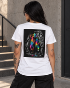 Female model shown from behind wearing a white T-shirt with a bold neon rainbow hoodie back print against a black-and-white graffiti background, styled with black cargo trousers for an expressive urban streetwear look.