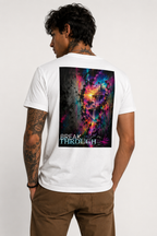 Back view of a tattooed male model wearing a white unisex V-neck T-shirt featuring the large “BREAK THROUGH” back print with a vivid surreal neon landscape, paired with brown trousers.