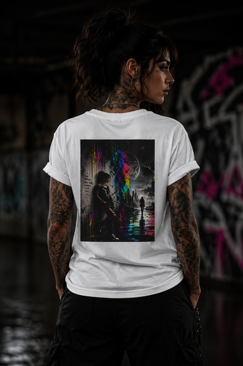 Tattooed woman wearing a Personiq Kaleido T-shirt with colorful neon street art artwork on the back in an urban night setting.